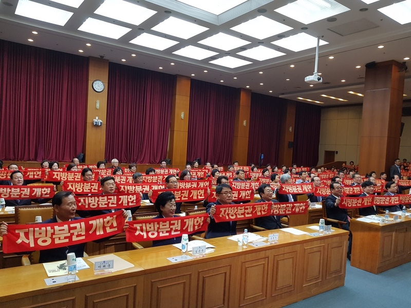 부산시청 12층 국제회의실에서 참가자들이 작은 펼침막을 펼치며 지방분권을 촉구하고 있다.