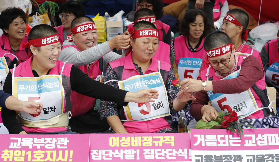 무기한 단식농성 중인 전국학교 비정규직 노동조합 조합원들이 추석 연휴가 시작된 1일 오전 서울 종로구 서울시교육청 앞에서 조합원이 보내온 장미를 머리에 꽂고 있다. 학교비정규직 노조 관계자는 "지역의 한 조합원이 장미가 시들기 전에 학교비정규직 문제가 해결되기를 바라며 보냈다"고 설명했다. 박종식 기자 anaki@hani.co.kr