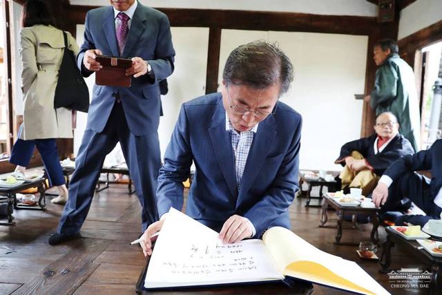경상북도 안동 하회마을 양진당에서 노무현 전 대통령이 10년 전에 남긴 방명록을 보고 있는 문재인 대통령. 청와대 페이스북