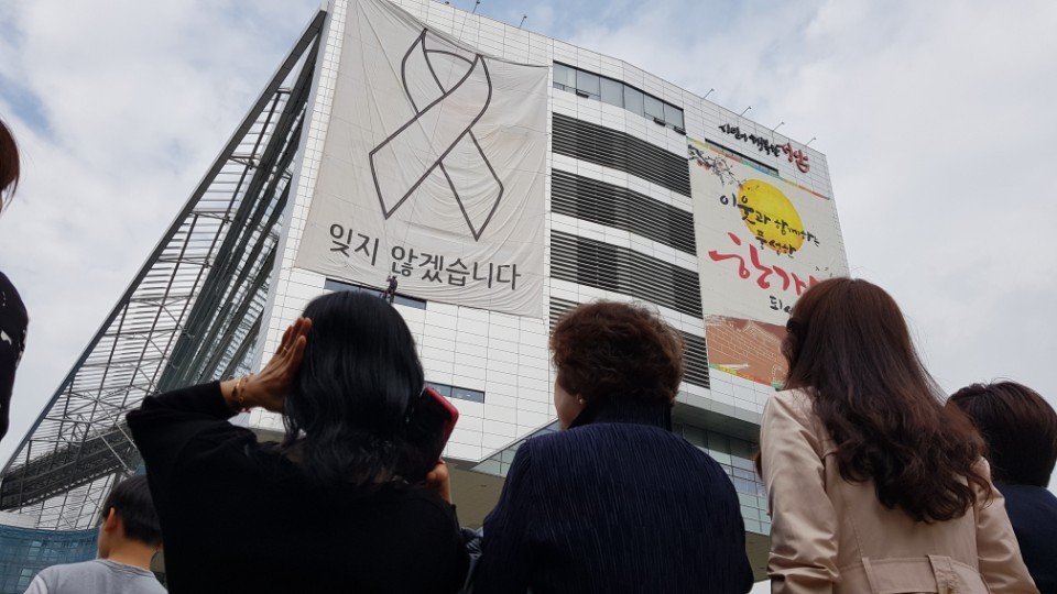 세월호 참사 희생자를 추모하는 의미로 경기도 성남 시청사 벽면에 걸렸던 대형 펼침막이 10일 오전 시민들이 지켜보는 가운데 철거되고 있다. 성남시 제공