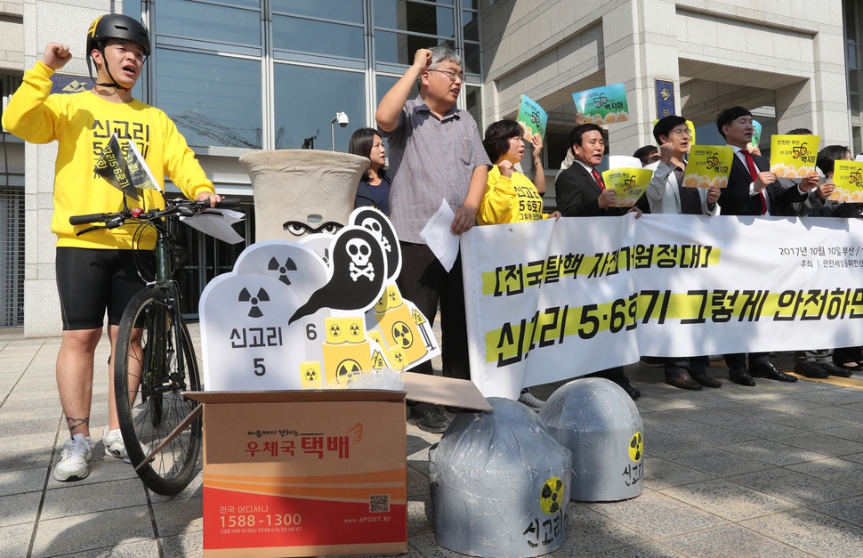 신고리5·6호기 백지화시민행동 회원들을 비롯한 탈핵단체 회원들이 10일 오전 부산시청 앞에서 신고리 5·6호기 부산∼서울 봉송 기자회견을 열고 구호를 외치고 있다. 서울에 거주하는 탈핵단체 소속 회원들은 이날부터 자전거와 차량을 이용해 4박 5일간 전국을 순회하며 부산에서 서울까지 신고리 5·6호기 모형을 옮긴다. 이들은 "수도권의 전력사용을 위해 부울경 시민들을 희생시키는 비상식적 전력정책을 중단하라"며 "전력을 가장 많이 사용하는 서울에서도 신고리 5·6호기 건설을 반대한다면 전국 어디서도 원전을 지을 수 있는 곳은 없다"고 주장했다. 연합뉴스