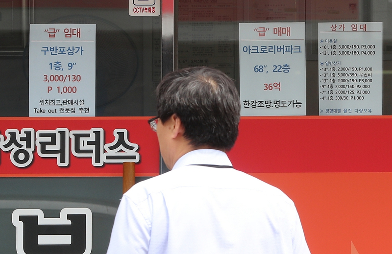 서울 서초구 부동산 앞에서 한 시민이 매물 목록 등을 살펴보고 있다. 한겨레 자료사진