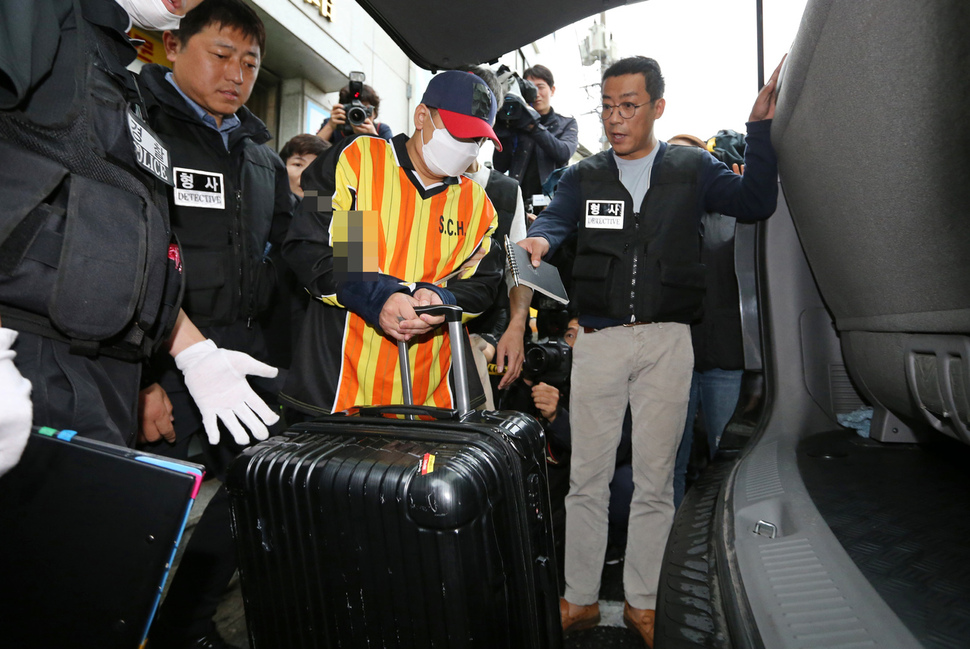 중학생 딸 친구 살해·시신 유기 사건의 피의자 ‘어금니 아빠’ 이아무개씨가 11일 오전 서울 중랑구 망우동 자택 앞에서 열린 현장 검증에서 주검을 담은 가방을 옮겨 차에 싣는 장면을 재연하고 있다. 연합뉴스