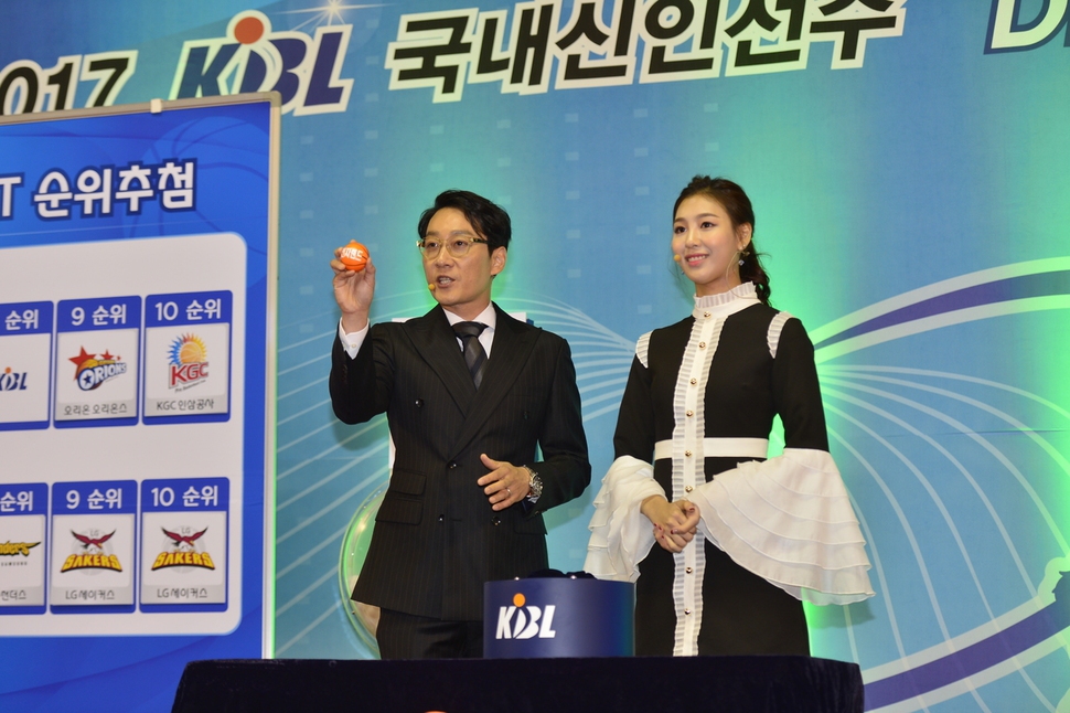 방송인 이휘재씨(왼쪽)가 리포터 안혜령씨와 함께 23일 서울 잠실학생체육관에서 열린 2017 프로농구 국내 신인선수 드래프트 구단 순위 추첨 행사에서 공을 뽑고 있다. 한국농구연맹(KBL) 제공