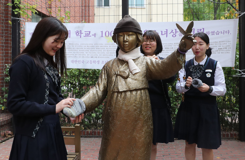 이화여고 역사동아리 학생들이 ‘학생의 날’을 기념하기 위해 2일 오후 서울 중구 정동 프란치스코 교육회관 앞에 있는 소녀상 앞에 모여 목도리, 모자, 장갑을 둘러주고 있다. 이 학교를 비롯해 전국 218개 학교 학생들은 이날 ‘일본군 위안부 문제 해결을 위한 학생 나비선언’을 발표했다. 이들은 선언에서 “오늘은 1929년 일제에 맞서 싸운 광주학생운동 88주년이 되는 학생의 날”이라며 “학생들의 뜻을 이어받아 가장 아픈 역사, 일본군 위안부 문제 해결을 앞당기고자 한다”고 밝혔다. 신소영 기자 viator@hani.co.kr