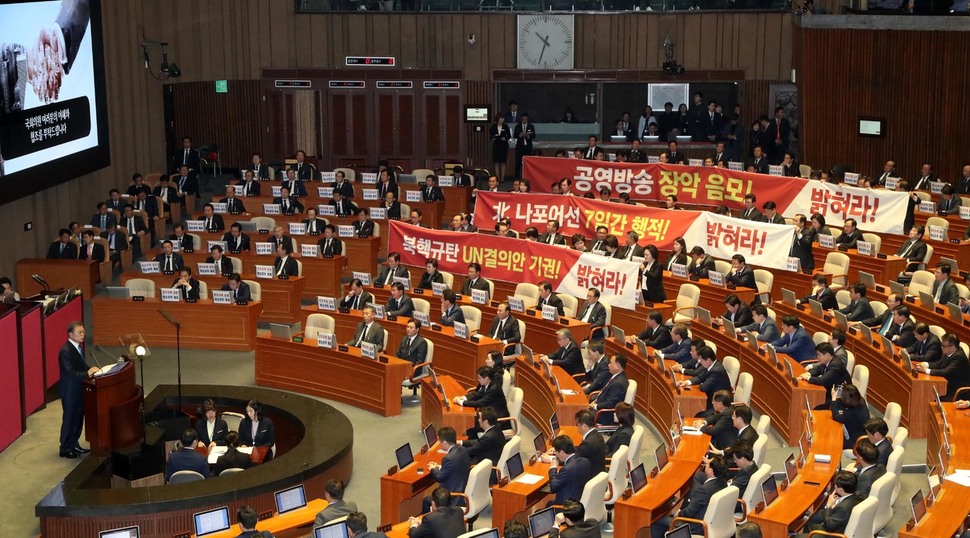 문재인 대통령이 1일 오후 국회 본회의장에서 새해 예산안 시정연설을 하는 동안, 자유한국당 의원이 펼침막을 들고 일어나 시위를 벌이고 있다. 이정우 선임기자