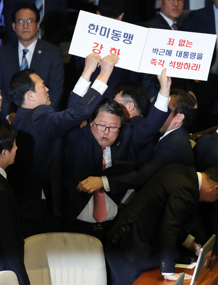 조원진 대한애국당 의원이 8일 국회 본회의장에서 박근혜 전 대통령을 석방하라는 내용의 손팻말을 들었다가 쫓겨나가고 있다. 사진공동취재단