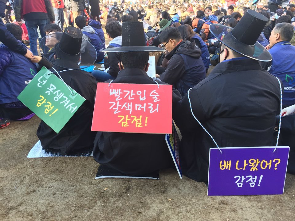 원주 원예농협 소속 비정규직 조합원들이 농협중앙회의 작의적인 친절·봉사 점수 매기기를 비판하는 팻말을 몸에 걸고 전국노동자대회에 참여하고 있다.