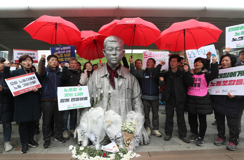 전태일 열사 47주기인 13일 오전 서울 청계천 전태일다리에 모인 ‘노조하기 좋은 세상 운동본부’ 회원들이 연대와 노동조합의 의미를 담은 우산을 씌워주고 있다. 신소영 기자