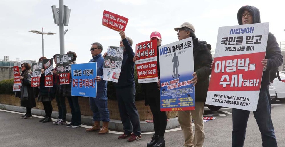 이명박 전 대통령이 바레인으로 출국한 12일 낮 인천공항에서 시민들이 이 전 대통령에 대한 수사를 촉구하며 손팻말을 들고 있다. 인천공항/박종식 기자 anaki@hani.co.kr