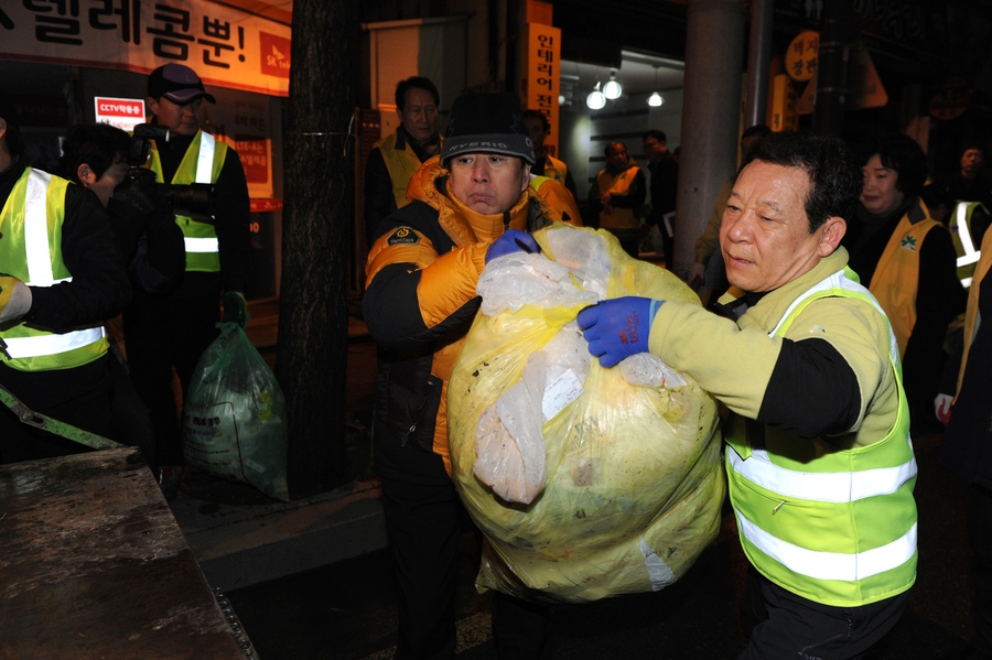 윤장현 광주광역시장이 지난 2015년 새벽 환경미화원들과 함께 생활쓰레기를 수거차에 싣고 있다. 광주시 제공