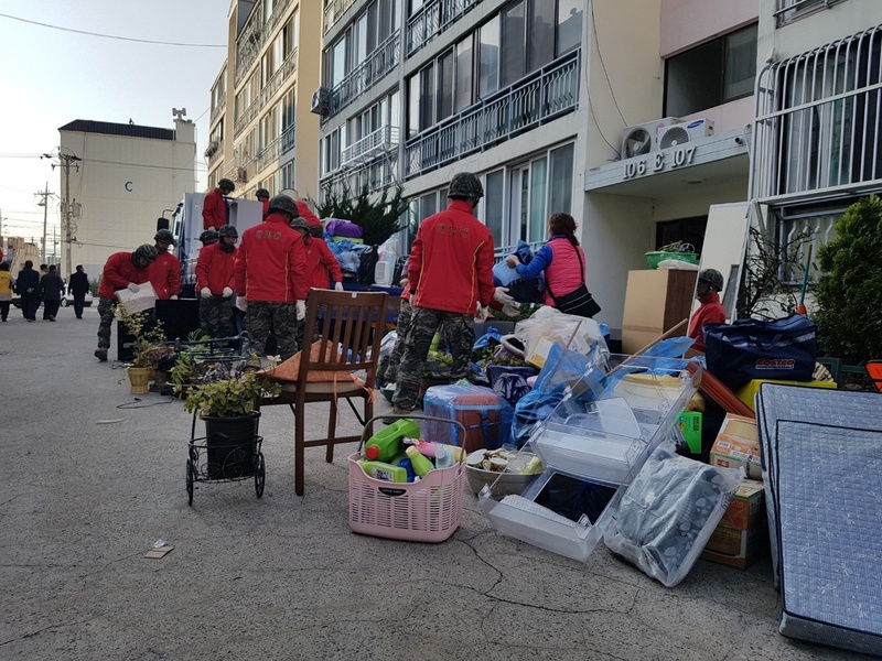 지난 18일 오후 4시께 경북 포항시 북구 흥해읍 대성아파트 E동 주민들이 집 안의 물건을 밖으로 가지고 나오고 있다.