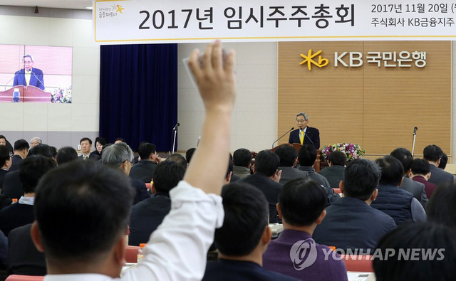 20일 서울 여의도 케이비(KB)국민은행 본점에서 열린 케이비금융지주 임시 주주총회에서 노조원 주주가 윤종규 회장에게 질의를 하려고 손을 들고 있다.
