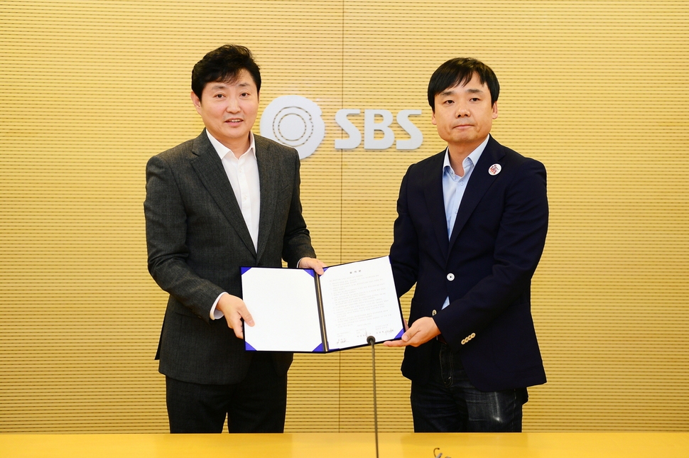 <에스비에스>(SBS) 노사는 지난달 13일 ‘사장 임명동의제’를 합의했다. 박정훈 에스비에스 대표이사 사장(왼쪽)과 윤창현 전국언론노동조합 에스비에스본부장이 합의서를 들고 사진 촬영을 하고 있다. 에스비에스 제공