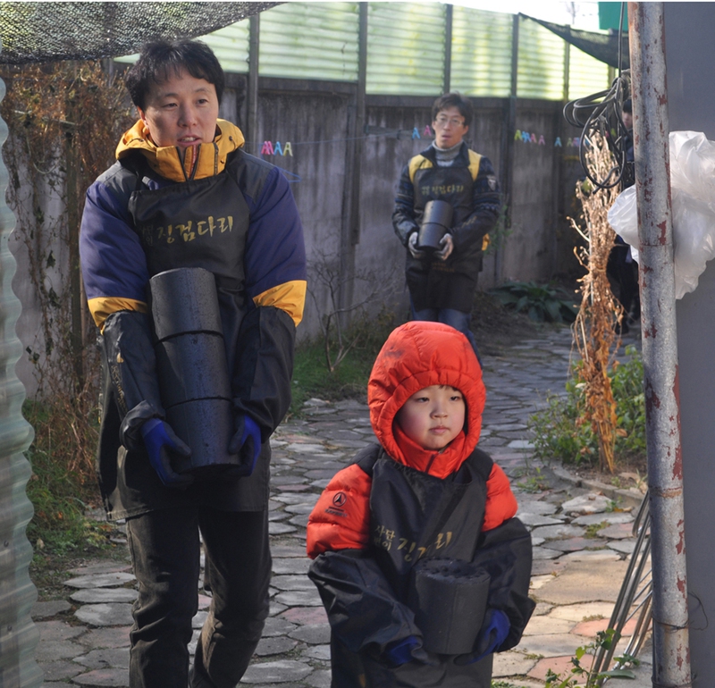 재청주 한양대 동문회 회원과 가족이 지난 18일 청주시 수동 한 주택에 연탄을 배달하고 있다. 재청주 한양대동문회 제공