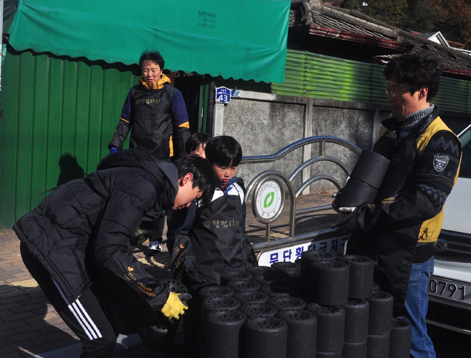 재청주 한양대 동문회 회원 등이 지난 18일 청주시 수동 한 주택에 연탄을 배달하고 있다. 재청주 한양대 동문회 제공