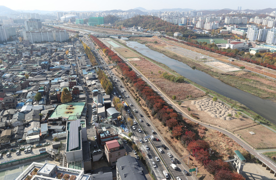 지난 15일 오전 서울 구로구 신도림동의 한 건물 옥상에서 바라본 서부간선도로 공기정화시설 공사 현장. 가운데 왕복 4차선 도로를 사이에 두고 오른쪽 아래에서 터널 공사가 진행 중이며 왼쪽 두 개의 굴뚝이 있는 자리가 공기정화시설이 지어질 자리다. 신소영 기자 viator@hani.co.kr