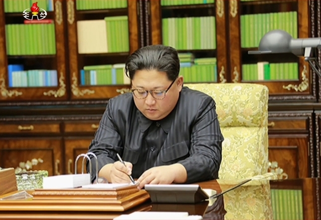북한이 29일 새로운 대륙간탄도미사일(ICBM)인 ‘화성-15형’ 미사일 발사에 성공했다고 발표했다. 조선중앙텔레비전이 공개한 화성-15형 미사일 발사를 지시하는 친필명령을 작성하고 있는 김정은 노동당 위원장의 모습. 연합뉴스