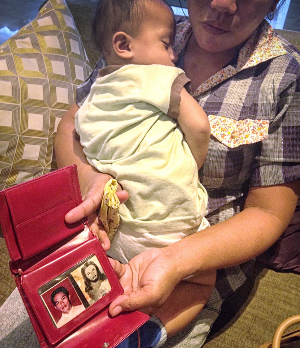 오룡501호에서 실종된 필리핀 선원 듀런의 사진을 아내가 지갑(왼쪽)을 펼쳐 보여주고 있다. 그의 품엔 남편이 한국 배를 타러 떠날 때(2014년 7월) 뱃속에 있던 아기가 안겨 있다. 공익법센터 어필 제공