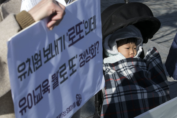 지난달 30일 ‘정치하는 엄마들’이 서울 종로구 정부서울청사 앞에서 연 기자회견에 엄마와 함께 나온 미취학 아동이 유모차에 누워 있다. 이들은 이날 기자회견에서 문재인 정부의 국공립 유치원·어린이집 취원율 40% 공약 달성을 위한 연도별 이행계획 공개를 촉구했다. 김성광 기자 flysg2@hani.co.kr