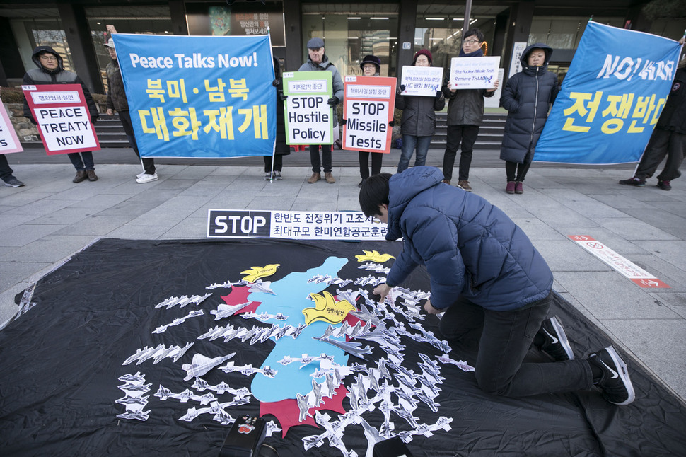 ‘평화와 통일을 여는 사람들’이 4일 오전 서울 종로구 주한미국대사관 주변에서 기자회견을 열어 F-22 등 미국의 전략무기가 한반도 상공을 뒤덮고 있는 모습을 나타낸 펼침막을 펼쳐보이고 있다. 이들은 북한의 핵 미사일 실험과 한국과 미국의 연합 군사훈련 동시 중단을 촉구했다. 김성광 기자