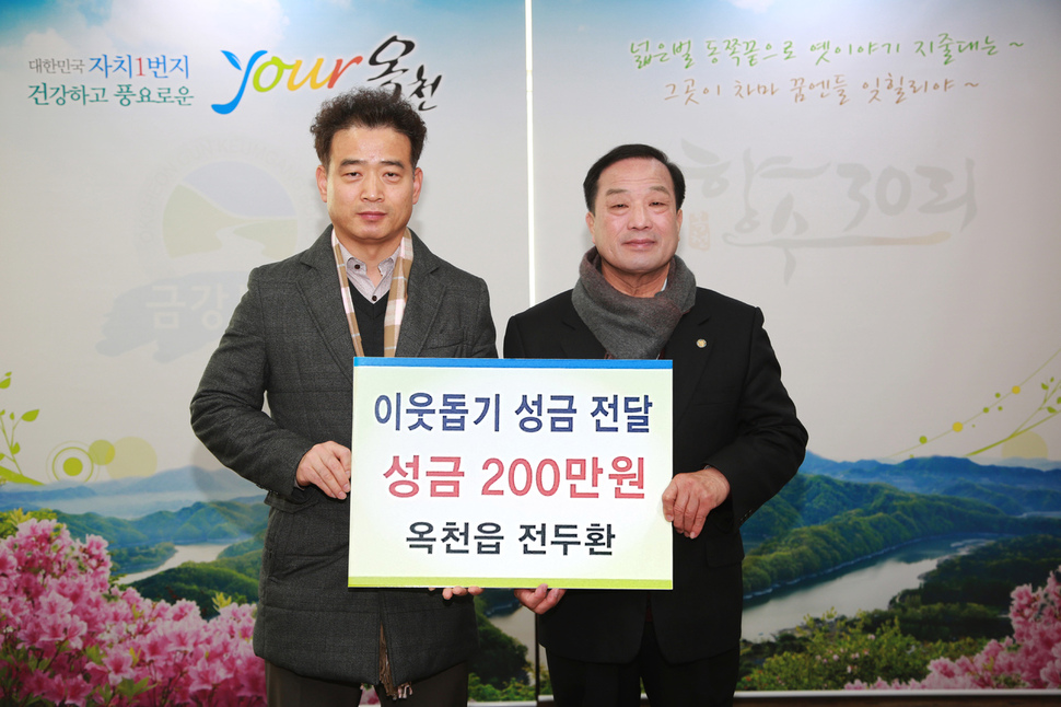 한발짝 달릴 때마다 1원씩 200만원을 적립한 옥천 마라톤맨 전두환씨(왼쪽)가 6일 김영만 옥천군수에게 성금을 건네고 있다.옥천군청 제공