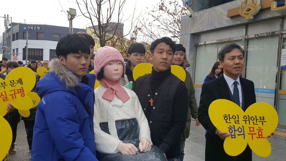 평화의 소녀상이 1000번 명품 시내버스를 타도록 학생들이 소녀상을 버스승강장으로 옮기고 있다.