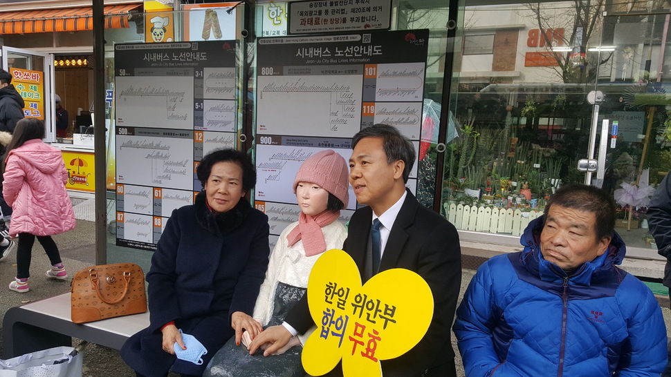 평화의 소녀상이 버스승강장에서 김승수(오른쪽에서 두번째) 전주시장 및 시민과 함께 앉아 있다.