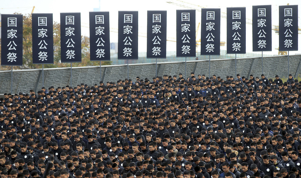 13일 난징대학살 80주기를 맞아 중국 장쑤성 난징시 대학살 희생자 기념관에서 열린 국가추모일 행사에서 시민들이 묵념하고 있다.  난징/AP 연합뉴스