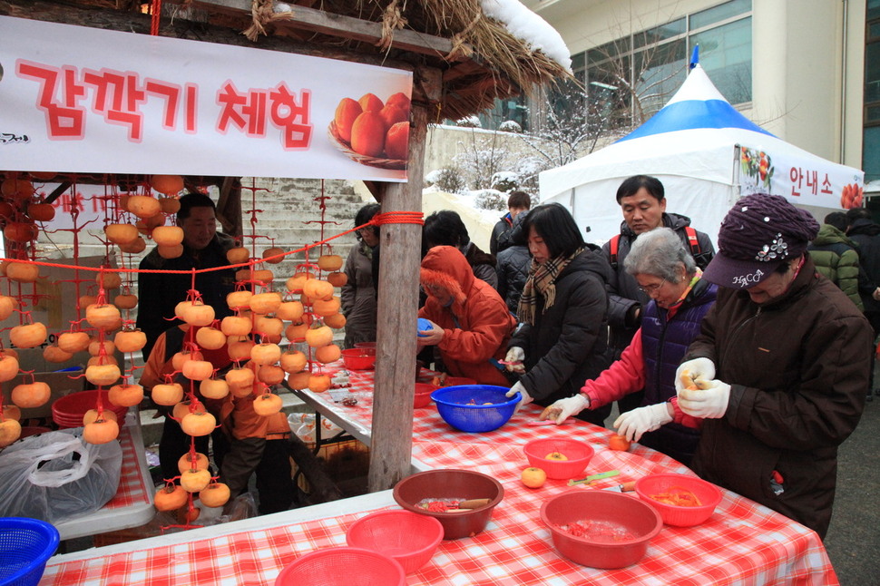 영동 곶감축제장을 찾은 시민들이 곶감 깎기 체험을 하고 있다.영동군청 제공