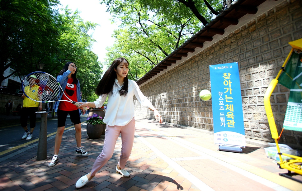 서울시민들이 서울 덕수궁 앞에서 진행된 서울시체육회의 ‘찾아가는 체육관’에 참여해 테니스를 즐기고 있다. 사진 서울시체육회 제공