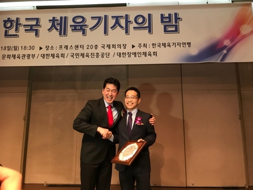 SBS 권종오(오른쪽) 기자가 18일 밤 서울 프레스센터 국제회의장에서 열린 한국 체육기자의 밤 행사에서 ‘이길용 체육기자상’을 받은 뒤  정희돈(왼쪽) 한국체육기자연맹 회장의 축하를 받고 있다. 한국체육기자연맹 제공