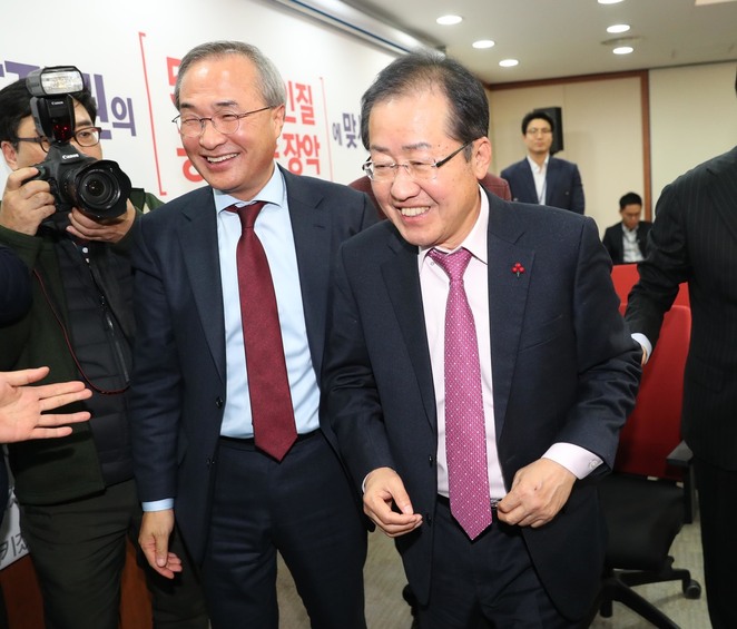 홍준표 자유한국당 대표(오른쪽)가 22일 오후 서울 여의도 당사에서 대법원이 ‘성완종 리스트’ 사건으로 기소된 자 신에 대해 무죄를 확정한 데 대해 기자회견을 마친 뒤 웃으며 대표실로 가고 있다. 왼쪽은 김대식 여의도연구원장. 강창광 기자 chang@hani.co