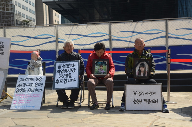 삼성반도체 온양공장에서 일하다 난소암을 얻어 숨진 은주씨의 아버지·어머니가 2016년 3월15일 같은 반도체 직업병 피해자 고 황유미씨 아버지 황상기씨와 함께 삼성전자 본관 앞에서 피켓시위를 벌어고 있다. 반올림 제공