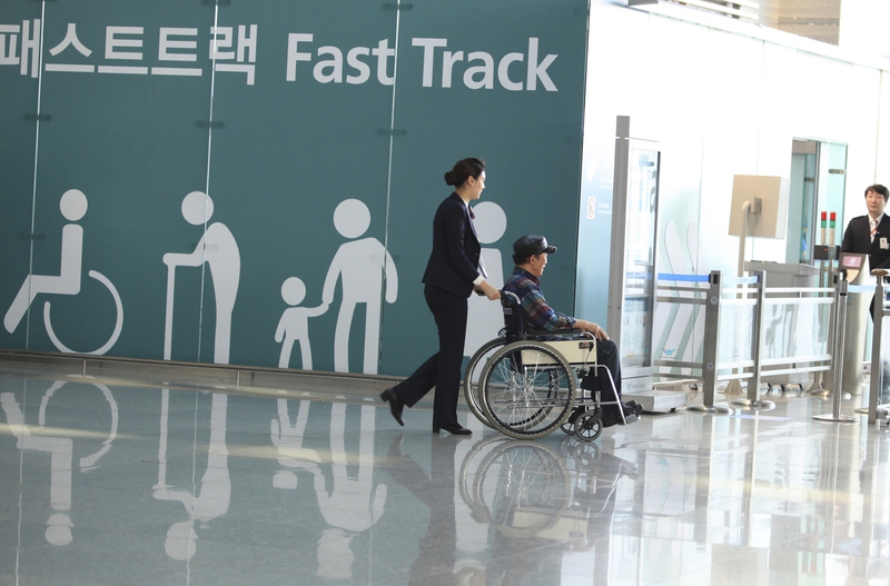 휠체어를 탄 한 공항 이용객이 인천국제공항 제1터미널에 설치된 교통약자를 위한 패스트 트랙을 통해 출국 심사를 받으러 가고 있다. 사진 인천공항공사 제공