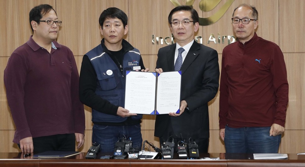정일영 인천공항공사 사장(오른쪽 둘째)과 박대성 민주노총 전국공공운수노조 인천공항지역지부 지부장(왼쪽 둘째)이 26일 오후 인천 중구 인천공항공사에서 열린 '인천공항 정규직 전환방안' 발표행사에서 합의서를 들어보이고 있다. 인천/박종식 기자 anaki@hani.co.kr