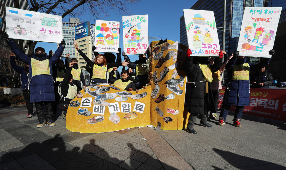 하이디스 해고 노동자들이 27일 오전 서울 중구 동화면세점 앞에서 ‘손배가압류’라고 쓰인 대형 신발 모형에 신발 사진을 붙이고 난 뒤 포즈를 취하고 있다. 신소영 기자 viator@hani.co.kr