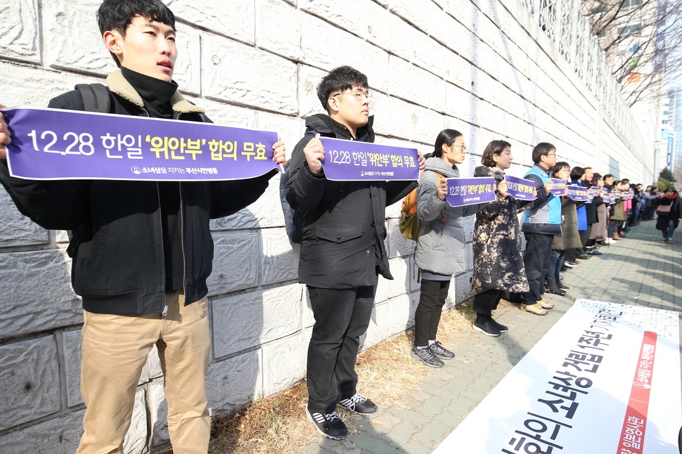 28일 부산 동구 초량동 일본총영사관 앞에서 ‘소녀상을 지키는 부산시민행동’이 소녀상 설립 1돌 기자회견을 열고 사람 띠 잇기 퍼포먼스를 하면서 12·28합의 무효를 촉구하고 있다.