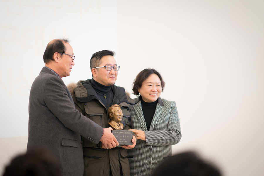 김근태 재단 이사장 인재근 의원(오른쪽)과 장영달 선정위원회 부위원장(왼쪽)이 29일 윤민석(가운데)씨에게 민주주의자 김근태상 상패를 전달하고 있다. 김근태 재단 제공