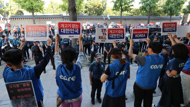 동물권단체 케어 회원들이 지난해 9월22일 오후 서울 종로구 효자로에서 대한육견협회가 ‘개고기 합법화 촉구 집회' 뒤 청와대 방향으로 행진하는 동안 개고기를 반대하는 내용의 손팻말을 들고 시위를 벌이고 있다. 김정효 기자opd@hani.co.kr