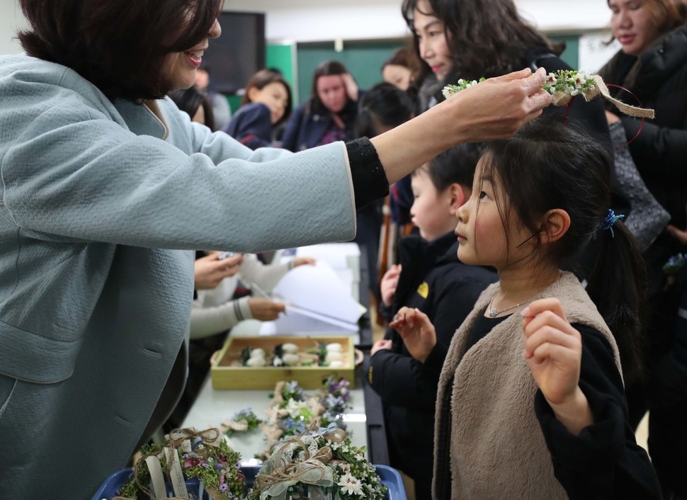 8일 오후 서울 용산구 용암초교에서 교감선생님이 예비 초등학생들에게 화관을 선물하고 있다. 백소아 기자