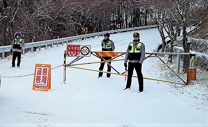 10일 오전 눈으로 뒤덮인 경남 산청군 밤머리재에서 경찰이 차량 운행을 통제하고 있다. 경남경찰청 제공