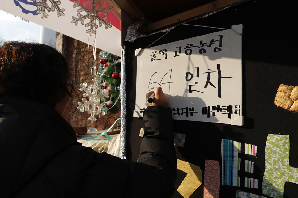 신유아 문화연대 활동가가 14일 오전 서울 양천구 목동 열병합발전소 앞 농성장에 붙여진 현황판에 고공농성 날수를 고쳐쓰고 있다. 이정아 기자 leej@hani.co.kr