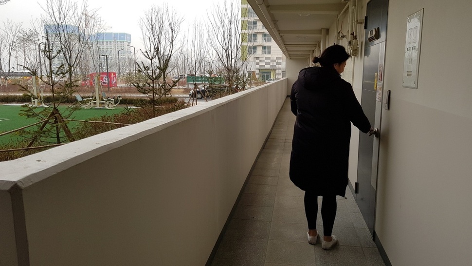 지난해 12월 주민 입주가 시작된 경기 화성시 봉담2지구 아파트에는 아파트 복도 통로와 외부를 차단하는 새시가 없다. 한 주민이 문을 열고 있다. 홍용덕 기자