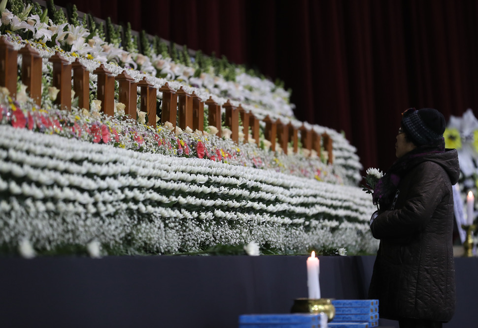 27일 오전 경남 밀양시 삼문동 밀양문화체육회관에 마련된 밀양 세종병원 화재 희생자 합동분향소에서 한 추모객이 헌화하고 있다.  연합뉴스