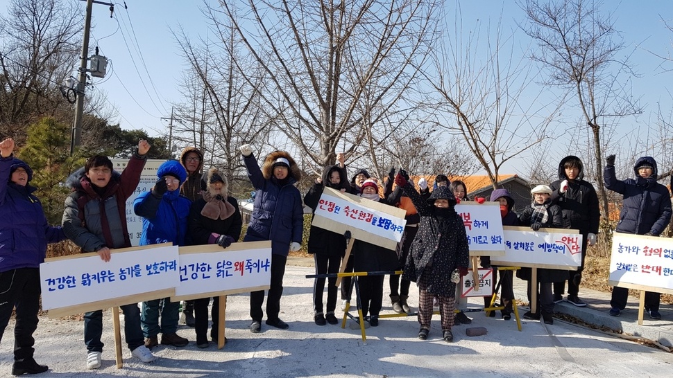 29일 경기도의 예방적 살처분에 항의해 무소유 마을로 알려진 화성시 향남읍 산안마을 주민들이 농장 입구에서 관행적인 예방적 살처분 반대 시위를 하고 있다.