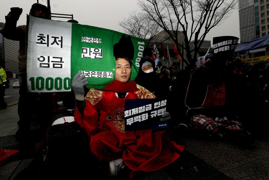 30일 오후 서울 세종로 정부서울청사 앞에서 '최저임금 인상 무력화 규탄, 최저임금제도 개악 저지 민주노총 결의대회'가 열려, 한 참가자가 최저임금 인상을 무력화려는 시도를 풍자하며 분장을 하고 앉아 있다. 박종식 기자 anaki@hani.co.kr
