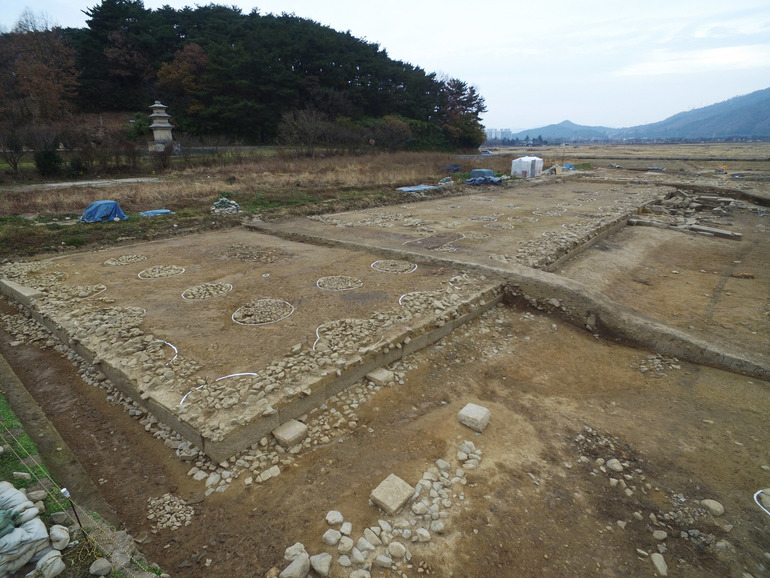 경주 낭산 기슭에서 발견된 대형왕실사원 추정 유적의 일부인 대석단 건물터. 국내 발굴사상 최대규모의 기단부와 회랑을 두른 시설터다. 뒤쪽에 전 황복사터 3층석탑과 낭산 자락이 보인다.