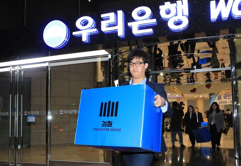 지난 7일 오후 서울 중구 회현동 우리은행 본점에서 채용비리 사건과 관련해 우리은행을 압수수색을 벌인 서울북부지방검찰청 직원들이 압수품을 들고 나오고 있다. 연합뉴스