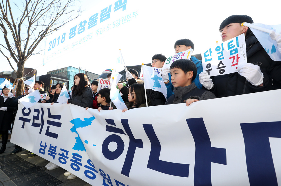 2일 오전 강원 원주시 일산동 강원감영 앞에서 열린 '2018 평창동계올림픽 남북공동응원단 출범 기자회견'에서 참석자들이 응원구호가 적힌 손팻말과 한반도기를 흔들며 환호하고 있다.  연합뉴스